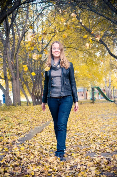 Frau, die in einem Park spaziert. Herbstzeit. — Stockfoto