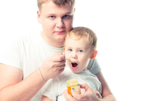 stock image Man feeding baby with a spoon, on white background