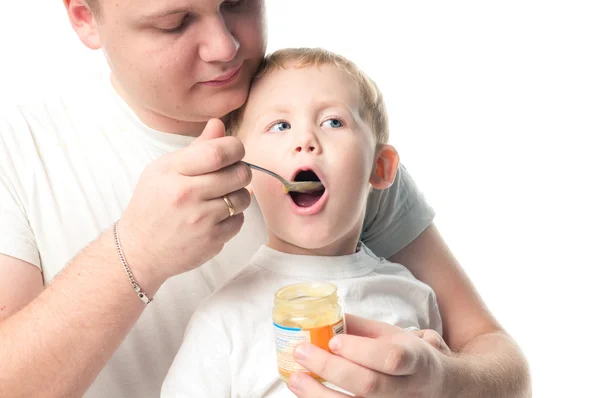 Hombre alimentando al bebé con una cuchara, sobre fondo blanco —  Fotos de Stock
