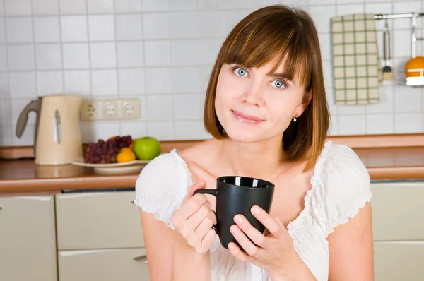 Mujer joven, disfrutando de una taza de café en su casa . — Foto de Stock