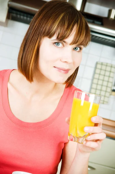 Jonge vrouw drinkt sinaasappelsap — Stockfoto