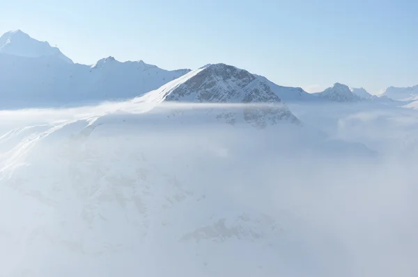 Горы в облаках с снегом зимой — стоковое фото