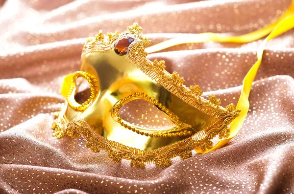 A szatén alapon arany maszk — Stock Fotó