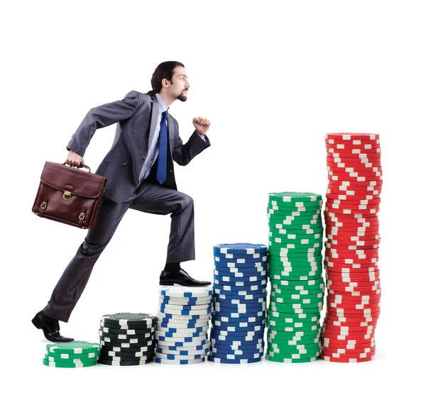 Empresario escalando pilas de fichas de casino —  Fotos de Stock