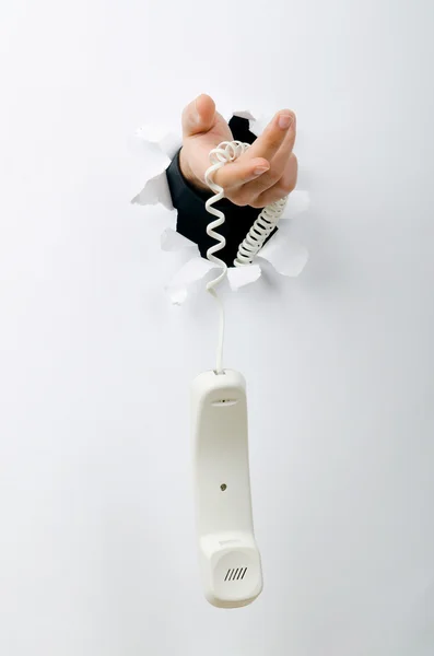 Kezében papír lyukon keresztül telefon — Stock Fotó