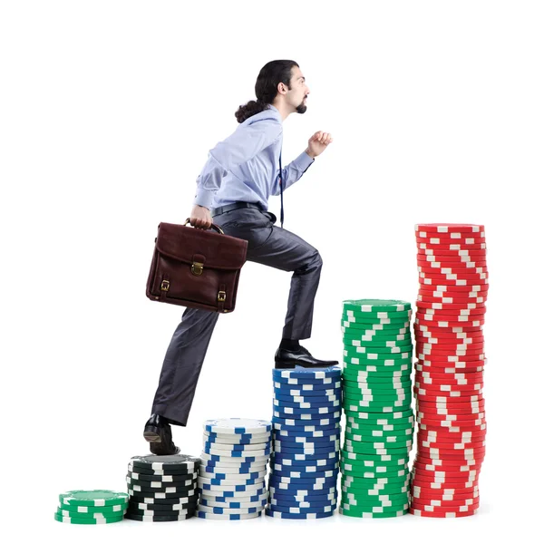 Businessman climbing stacks of casino chips — Stock Photo, Image
