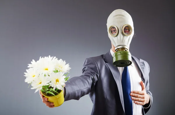 Üzletember, gázálarc és virágokkal — Stock Fotó