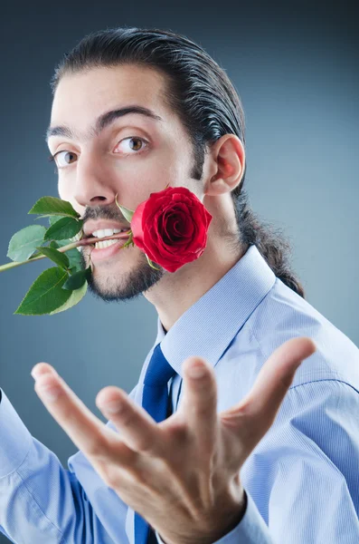 Młody człowiek z czerwoną różą — Zdjęcie stockowe