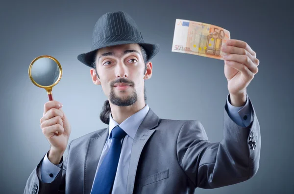 A nyomozó hamis pénzt keres. — Stock Fotó