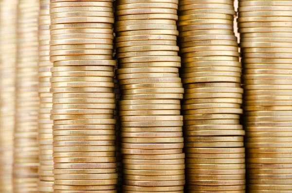 Golden coins in high stacks — Stok fotoğraf