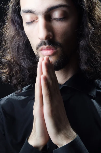 Młody człowiek modli się w ciemności — Zdjęcie stockowe