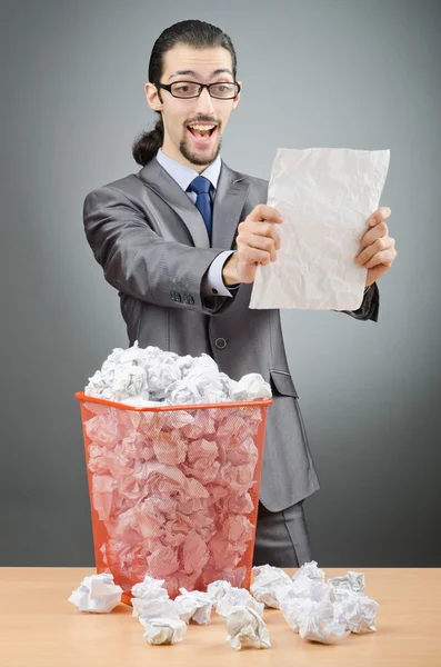 Homme avec beaucoup de papier gaspillé Photo De Stock