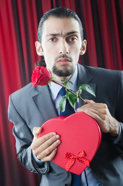 Mladý muž s červenou růží — Stock fotografie