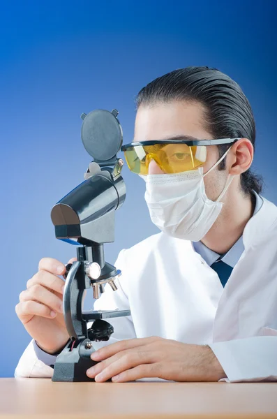 Химик, работающий с микроскопом — стоковое фото