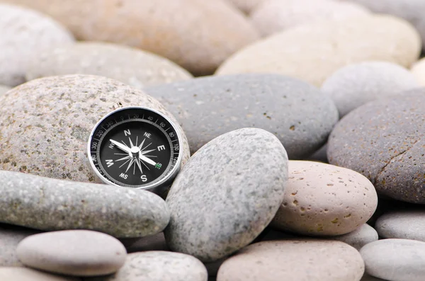 Navigation compass on stone pebbles — Stock Photo, Image
