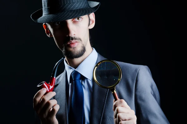 Detective with magnifying glass and pipe — Stock Photo, Image