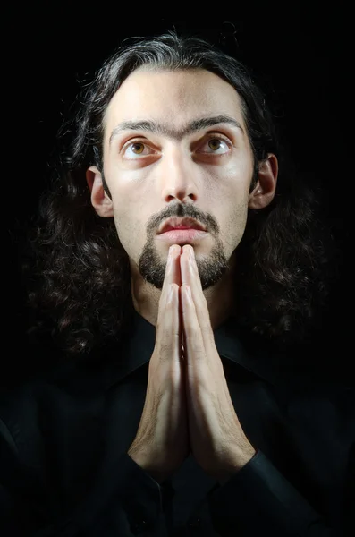 Jovem rezando na escuridão — Fotografia de Stock