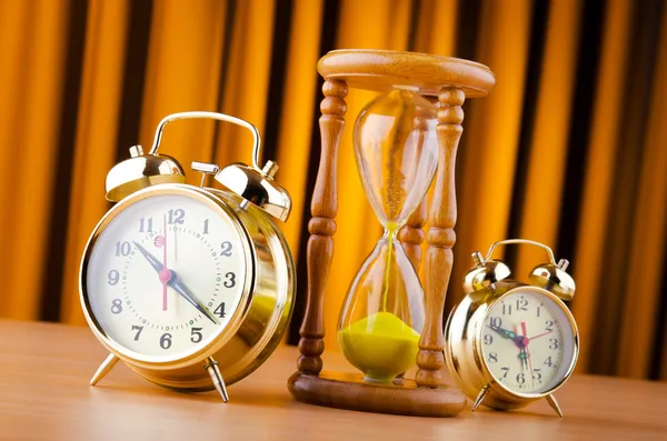 Концепція часу з будильником і пісочним годинником — стокове фото