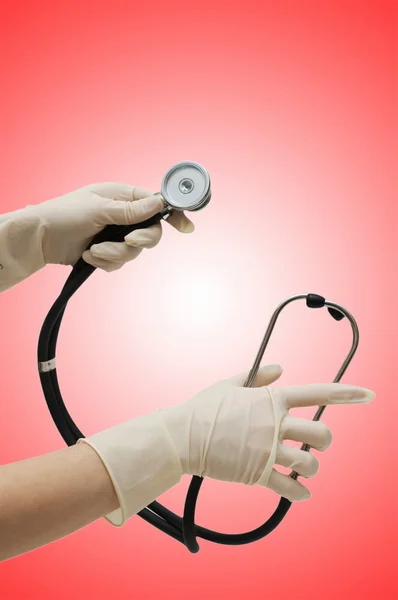Hand with stethoscope on gradient — Stock Photo, Image