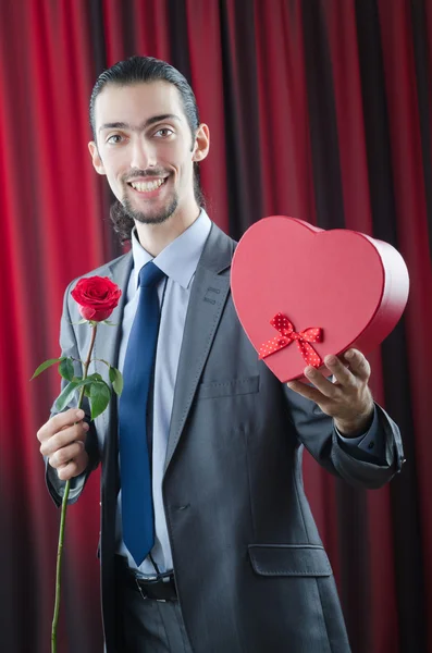 Молодой человек с красной розой — стоковое фото
