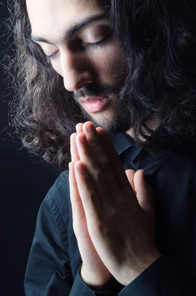 Jonge man bidden in de duisternis — Stockfoto