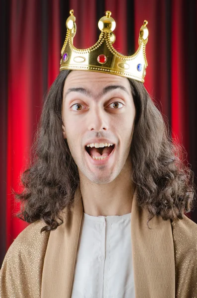 Rei engraçado contra cortina vermelha — Fotografia de Stock