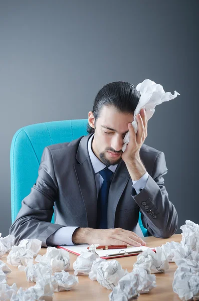 Zakenman met veel afgedankte papier — Stockfoto