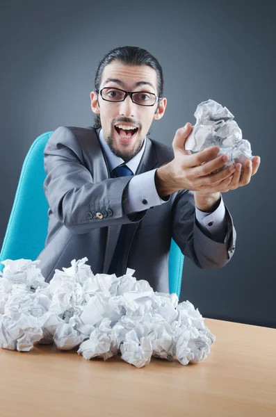 Businessman with lot of discarded paper Stock Picture