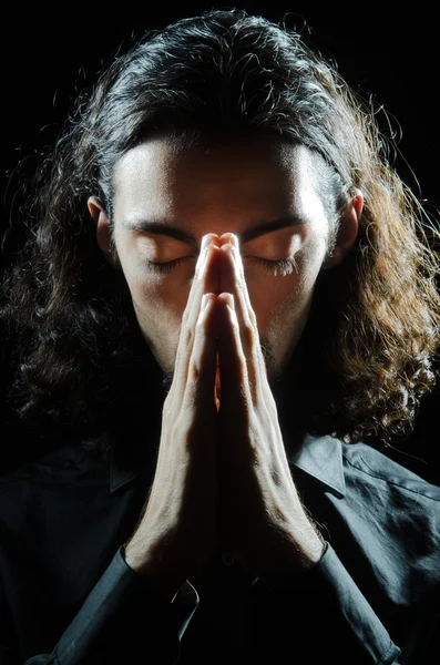 年轻男子在黑暗中祈祷 — 图库照片