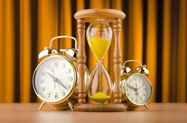 Relógios de alarme e ampulheta no conceito de tempo — Fotografia de Stock