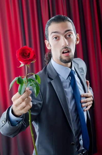Молодой человек с красной розой — стоковое фото