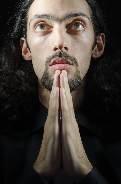 Giovane uomo che prega nelle tenebre — Foto Stock