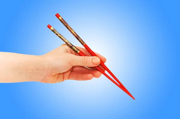 グラデーションの choipsticks を持っている手 — ストック写真