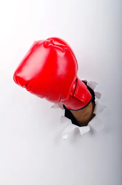 Hand in boxing glove through paper hole — Stock Photo, Image