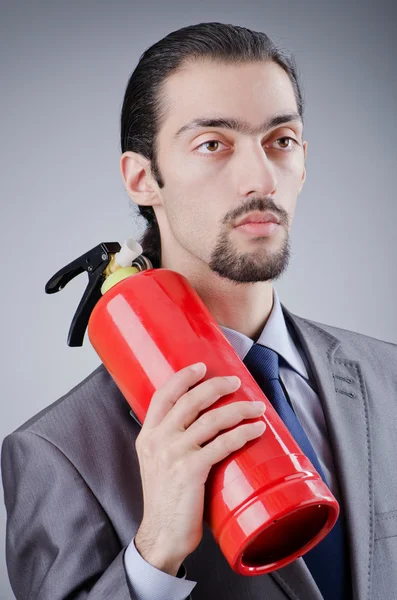 Man with fire extinguisher in firefighting concept — Stock Photo, Image