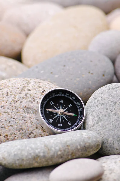 Навигационный компас на каменной гальке — стоковое фото