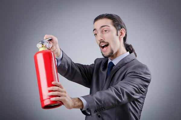 Hombre con extintor de incendios en concepto de extinción de incendios — Foto de Stock