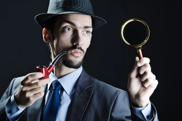 Detective with magnifying glass and pipe — Stock Photo, Image