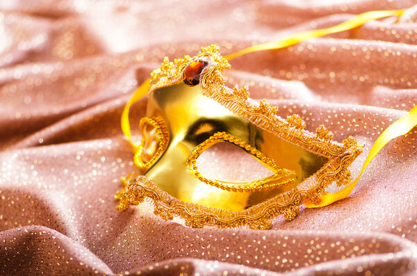 Золотая маска на атласном фоне

