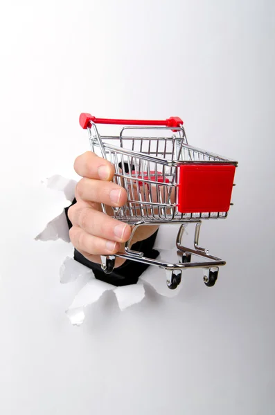 stock image Shopping cart through hole in paper