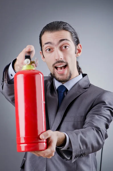 Man with fire extinguisher in firefighting concept — Stock Photo, Image