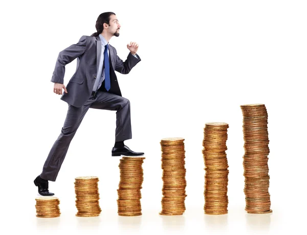 Businessman climbing gold coins stacks — Stock Photo, Image