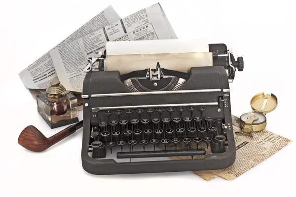 Винтажная пишущая машинка с бумагой и газетами — стоковое фото