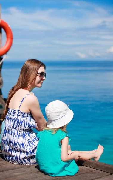 Anne ve kızı ahşap iskelede oturup — Stok fotoğraf