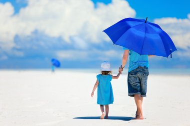 Baba ve kızı plajda yürüyüş