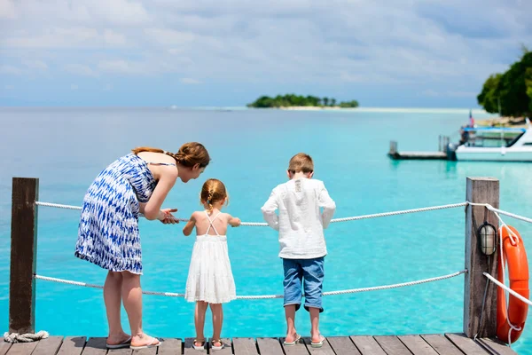 Mère et enfants assis sur un quai en bois — Photo