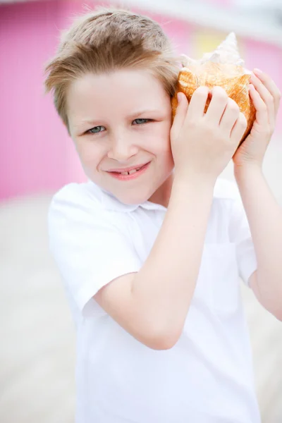 Симпатичный мальчик с ракушкой — стоковое фото
