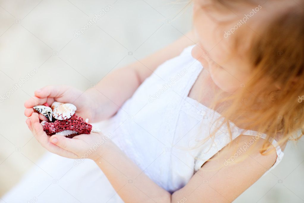 Little girl holding seashells