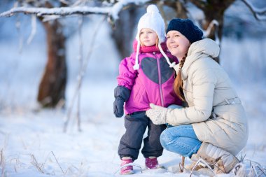 Mother and daughter outdoors at winter clipart