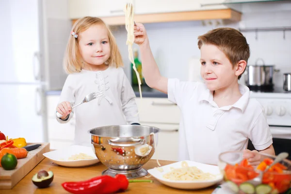 Duas crianças comendo espaguete — Fotografia de Stock